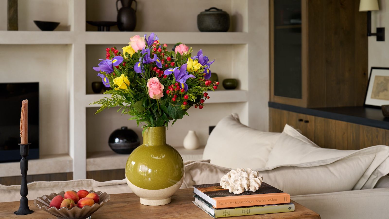 A rose, iris, Veronica, solidago and hypericum bouquet in a green vase.