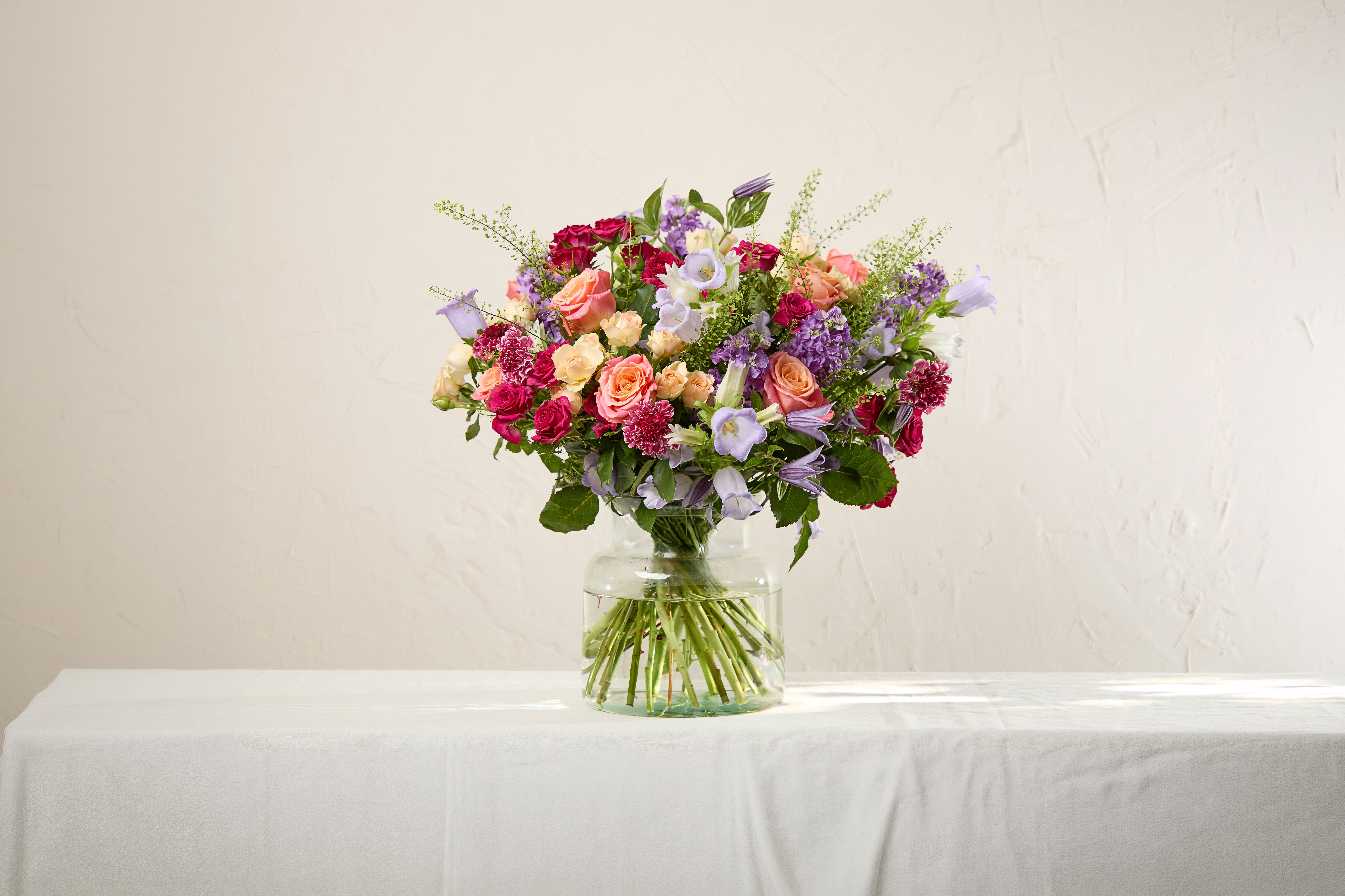 A bouquet of ‘Miss Piggy’ roses, peach spray roses, chayenne spray roses, raspberry scabiosa, lilac campanula, lilac clematis, lilac stocks and greenbell