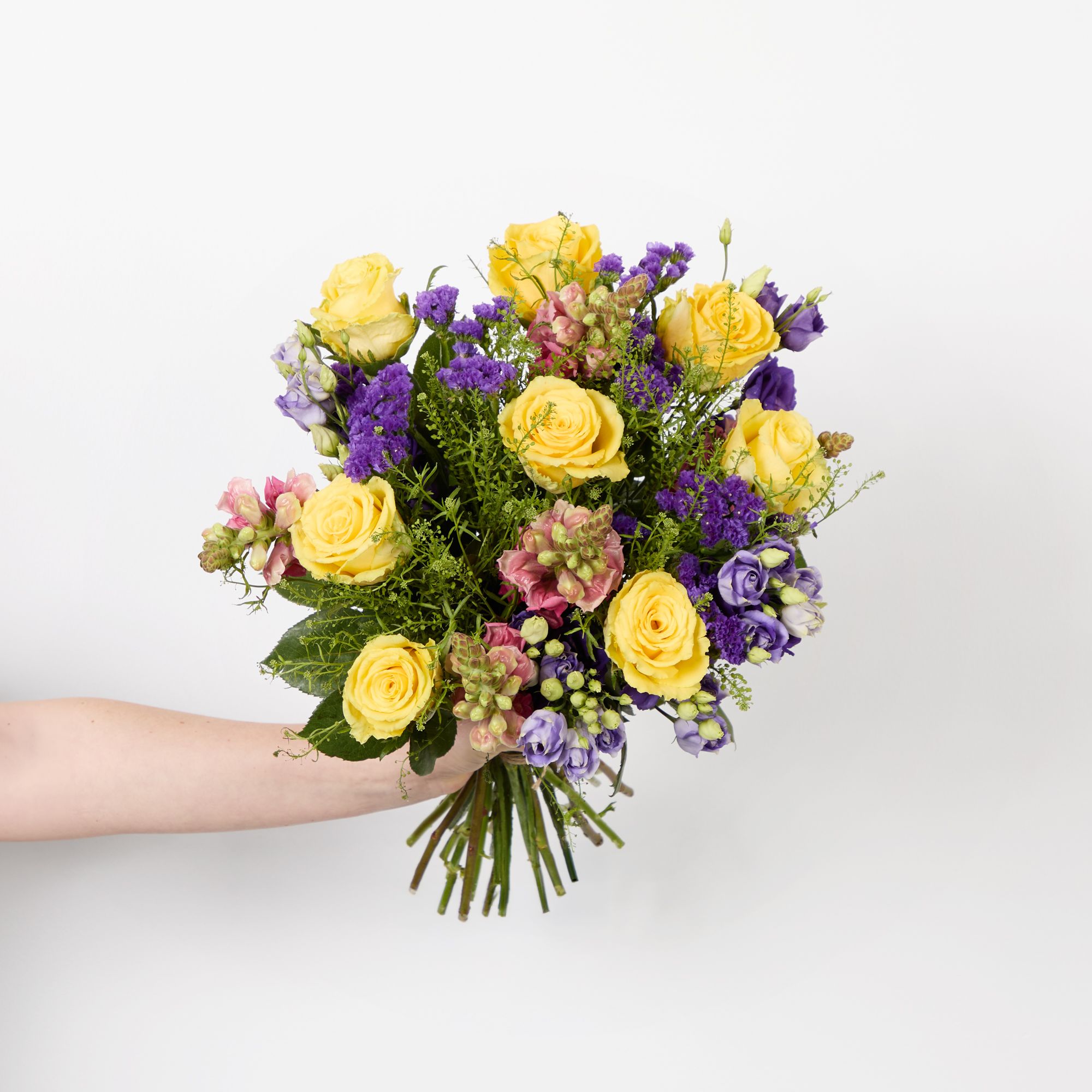 Yellow roses, purple lisianthus, purple statice, pink antirrhinums and greenbell