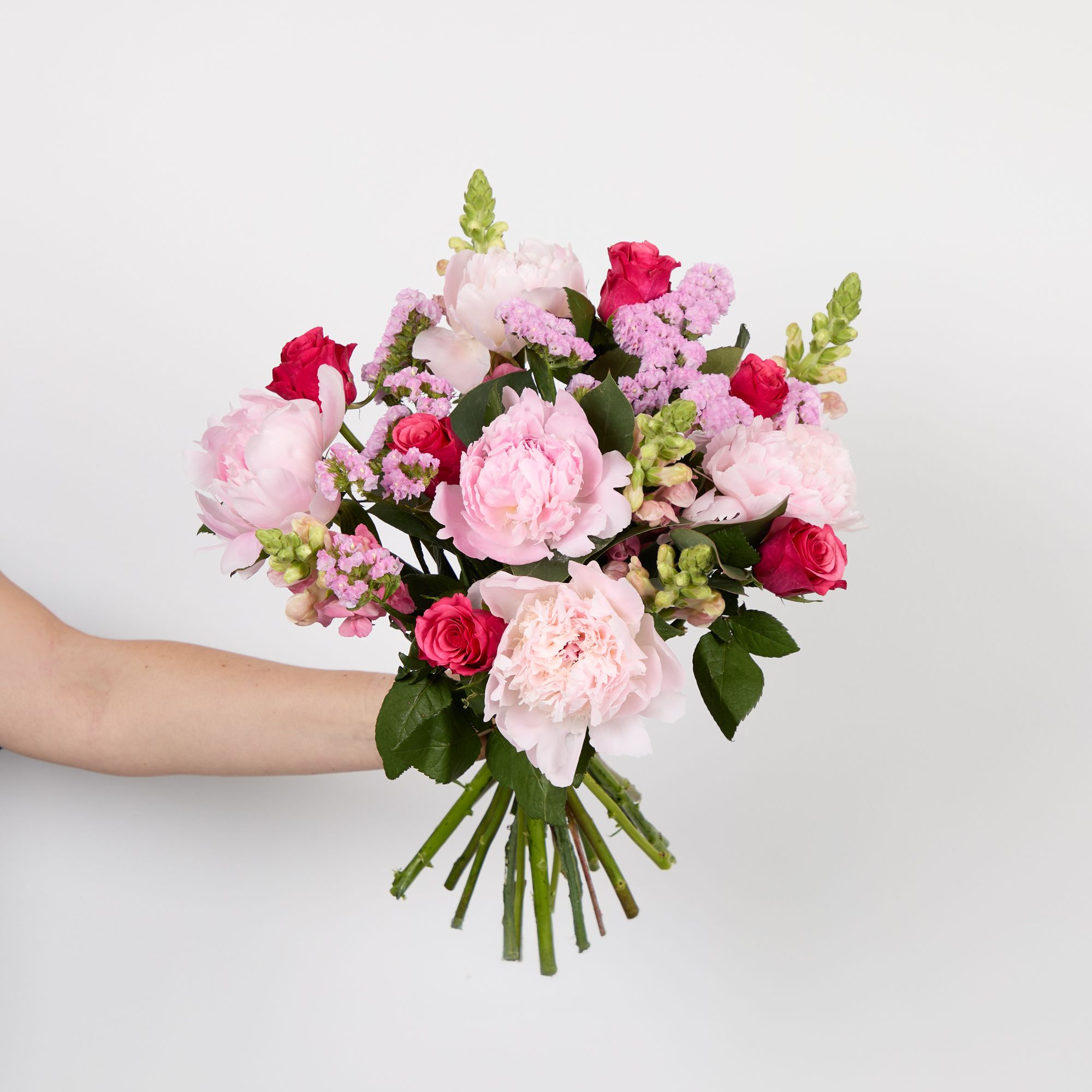 Cerise roses, pink peonies, pink antirrhinums, pink statice. and eucalyptus robusta