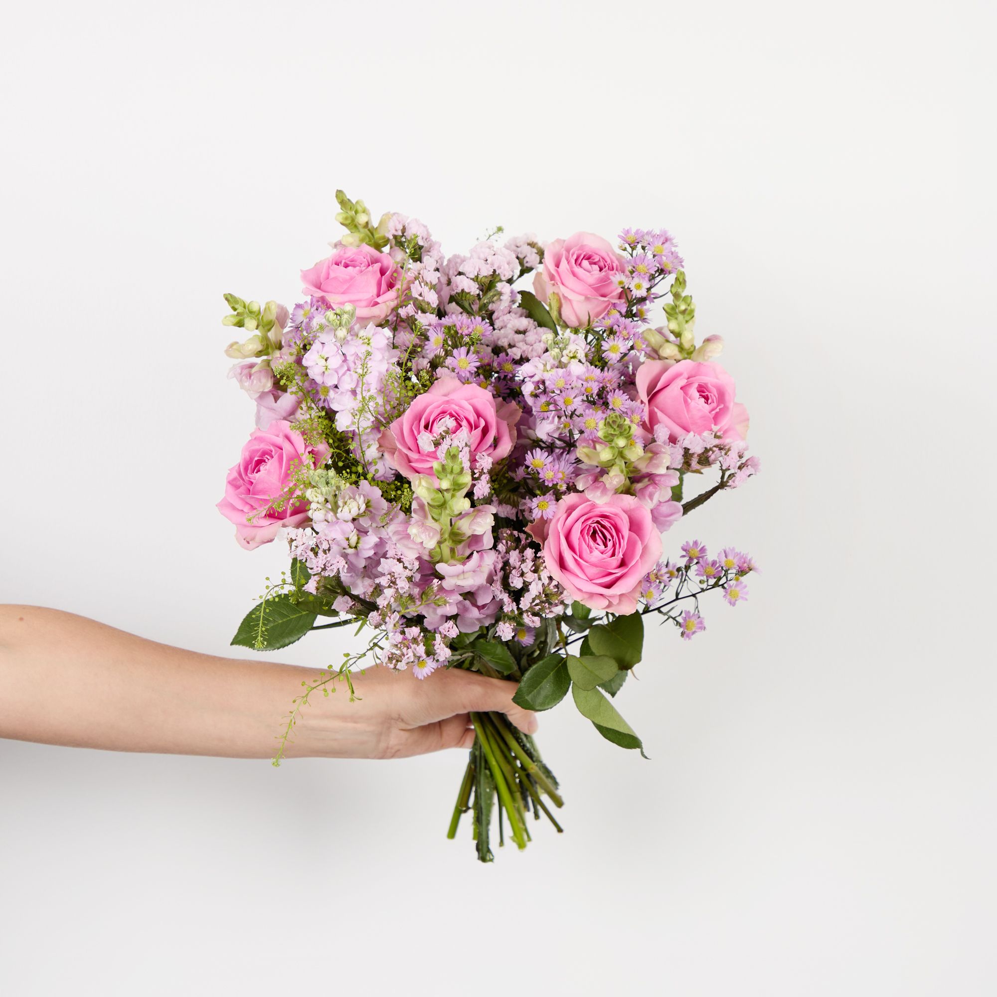 Pink roses, light pink stocks, lilac antirrhinums, pink asters, pink statice and greenbell