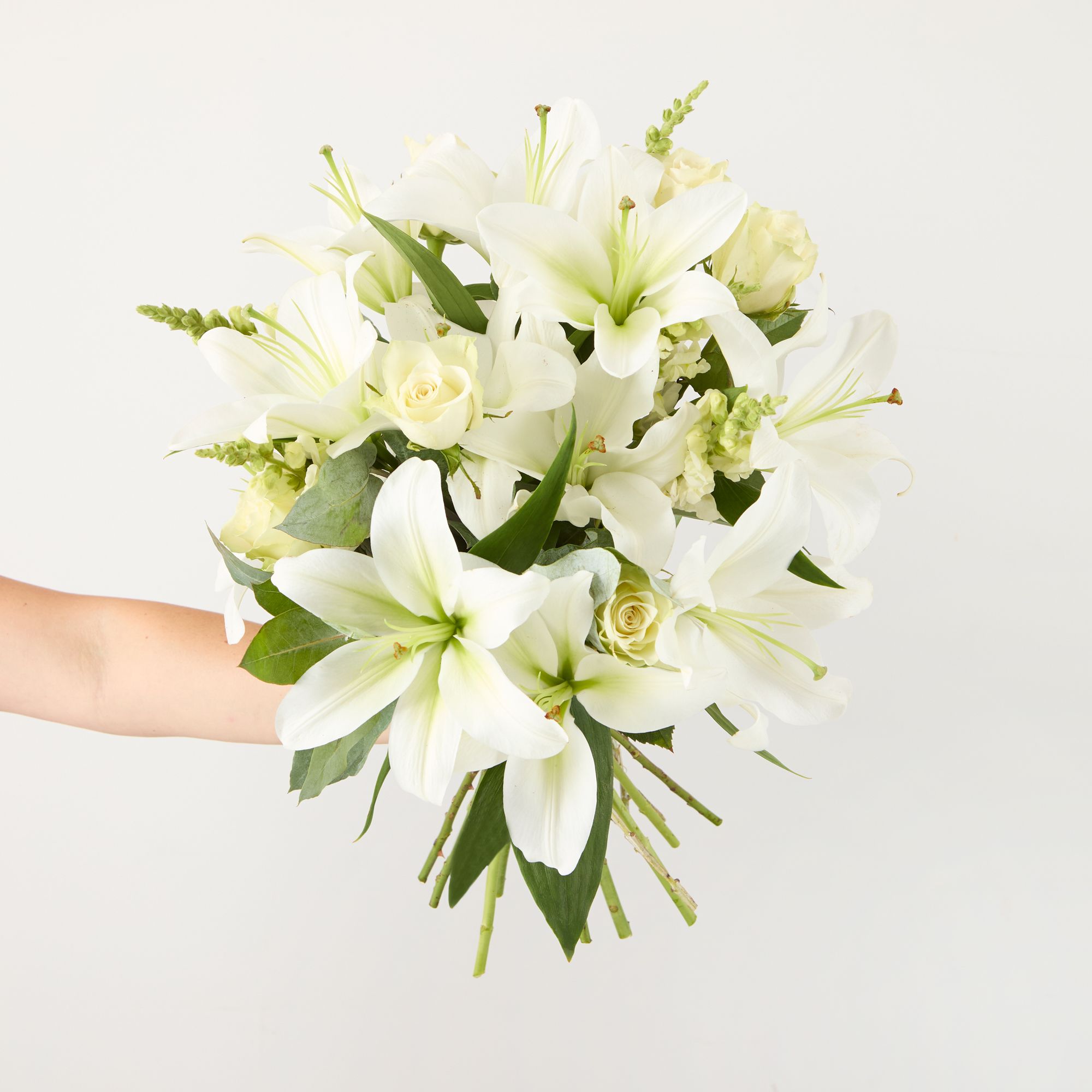 UK-grown white lilies, white roses, white antirrhinums and eucalyptus robusta