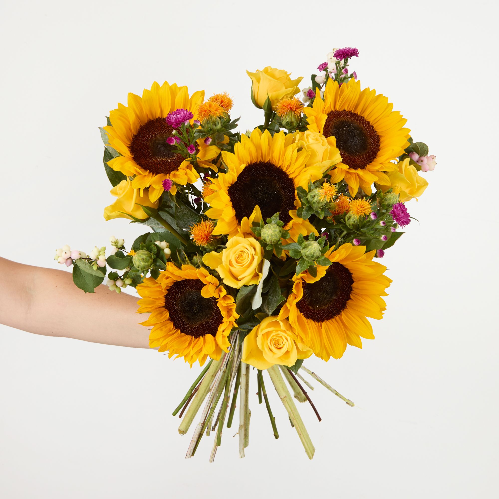 UK-grown sunflowers, yellow roses, pink snowberries, 'Flash' asters, orange carthamus and eucalyptus robusta