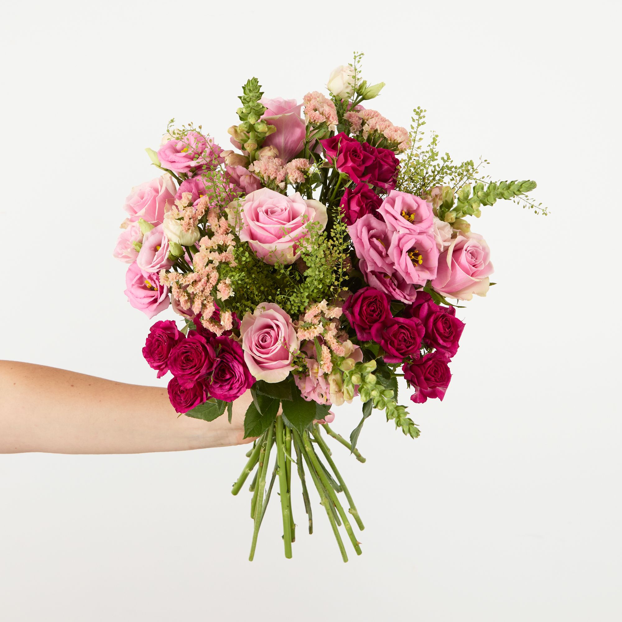 Pink roses, apricot statice, pink lisianthus, cerise spray roses, pink antirrhinums and greenbell