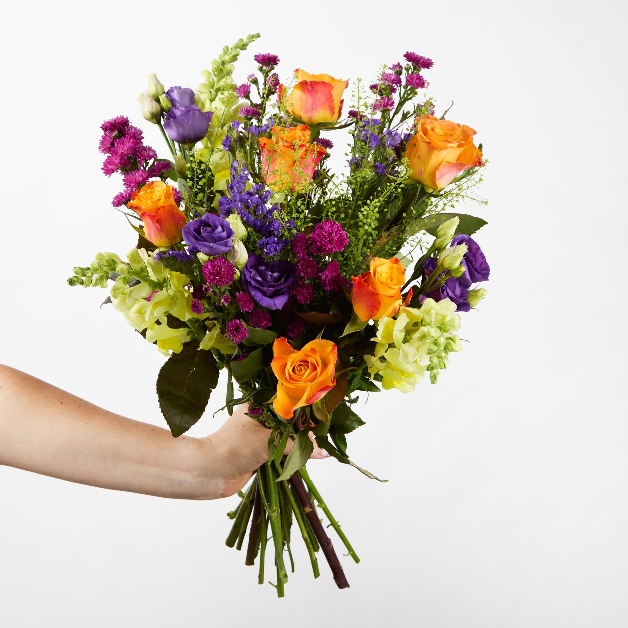 Orange roses, yellow antirrhinums, cerise asters, purple lisianthus, purple statice and greenbell