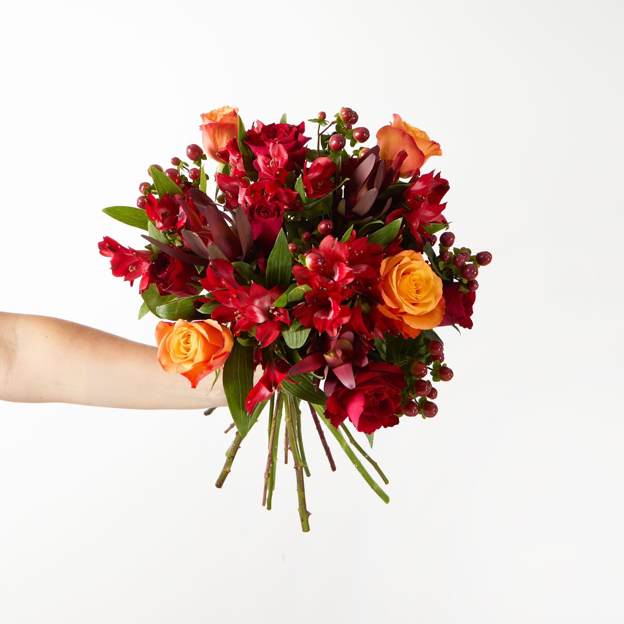 Orange roses, red roses, red alstroemeria, 'Cherry Dark Brown' hypericum, 'Safari Sunset' leucodendron