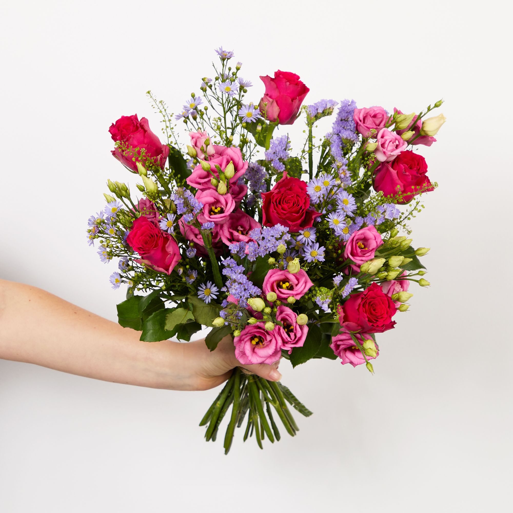 Pink lisianthus, lilac asters, lilac statice, cerise roses and greenbell